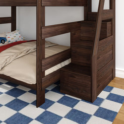 Dark walnut wooden bunk bed with built-in storage staircase drawers, beige bedding and car-print pillow on blue checkered rug in a kids' bedroom