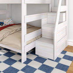 White wooden bunk bed with built-in storage stairs in children's bedroom, beige bedding, car-print pillow and blue-and-white checkered rug