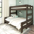 Dark wood twin-over-full bunk bed in modern farmhouse bedroom with mint-green paneled wall, neutral bedding, textured pillows, patterned area rug and natural window light
