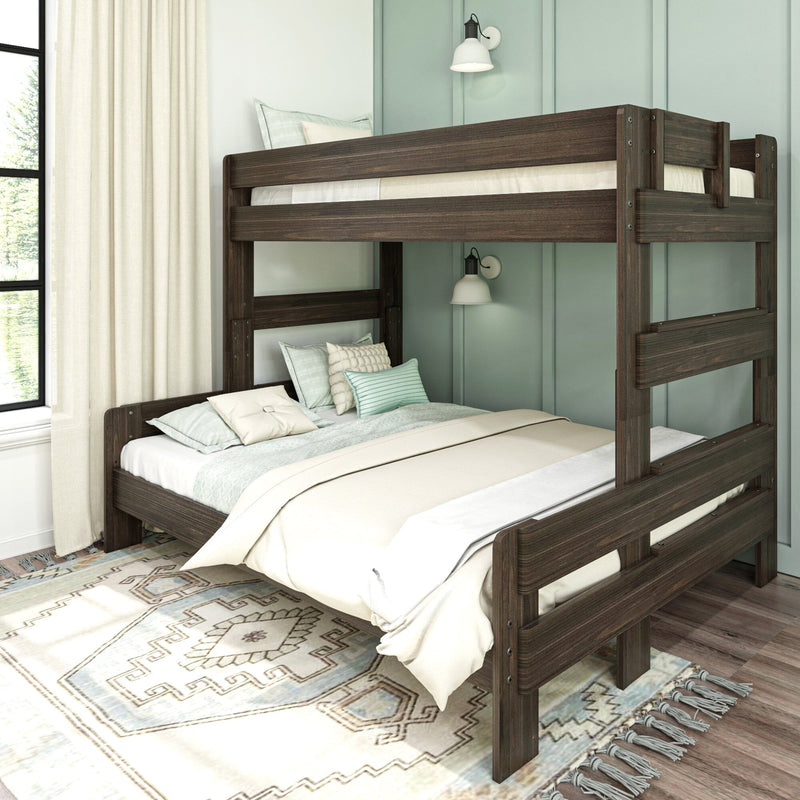 Dark wood twin-over-full bunk bed in modern farmhouse bedroom with mint-green paneled wall, neutral bedding, textured pillows, patterned area rug and natural window light
