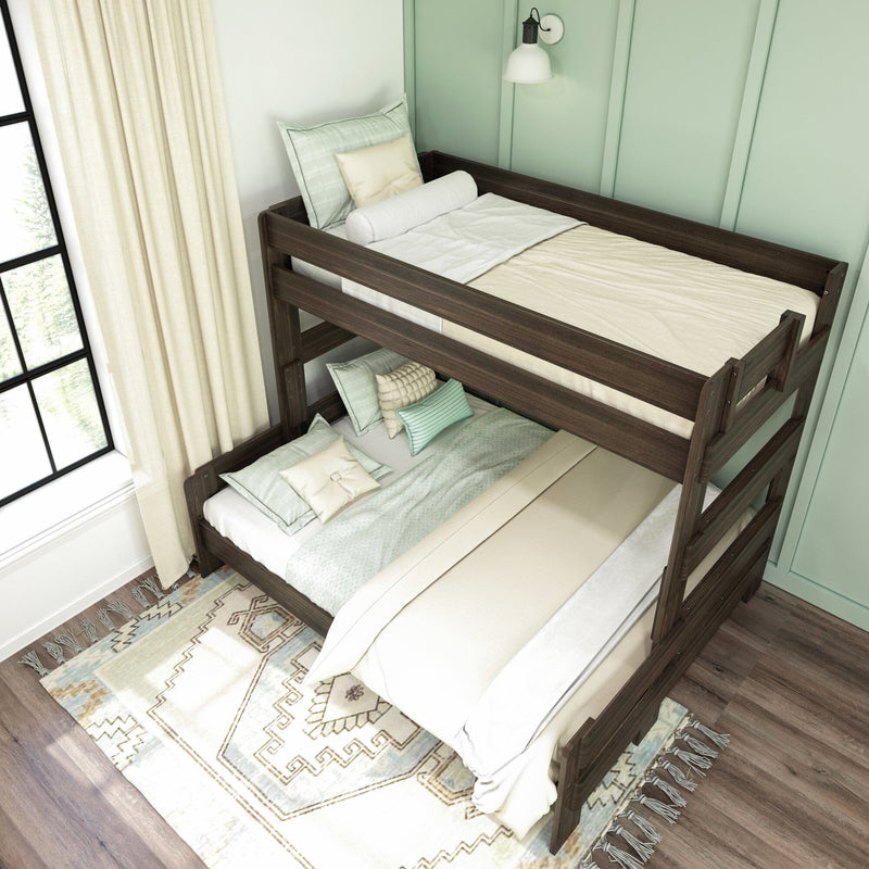 Dark wood twin-over-full bunk bed in modern mint-green bedroom with layered neutral bedding, decorative pillows, boho area rug and natural light