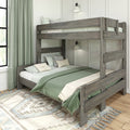 Rustic gray wooden twin-over-full bunk bed with green bedding, patterned area rug and wall sconce in bright modern farmhouse bedroom
