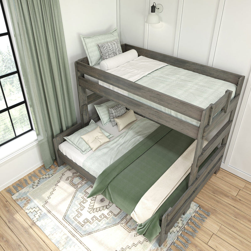 Gray farmhouse wooden twin-over-full bunk bed with ladder in cozy kids bedroom, green bedding, patterned area rug, large window and natural light