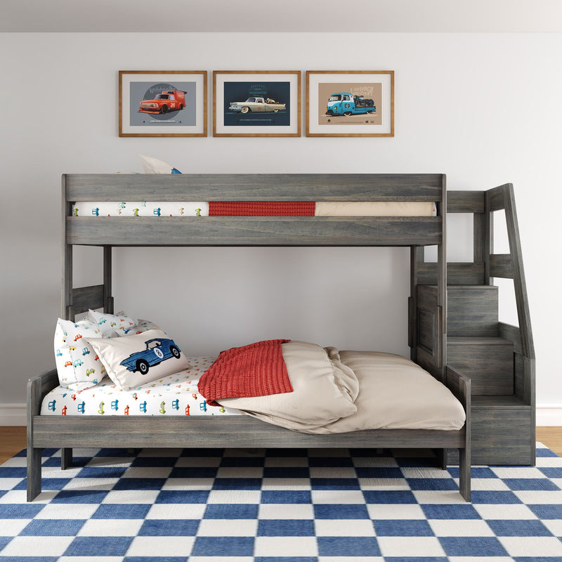 Gray wooden bunk bed with staircase storage in modern kids' bedroom, car-themed bedding, framed car prints and blue check rug