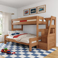 Natural wood bunk bed with built-in stairs and storage in a kids' bedroom, car-themed bedding and framed car prints, toy cars on a blue checkered rug