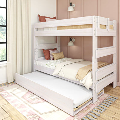 Whitewashed wooden bunk bed with pull-out trundle, neutral bedding and rust throw pillows in a cozy modern kids' bedroom with pink paneled wall and wall sconce