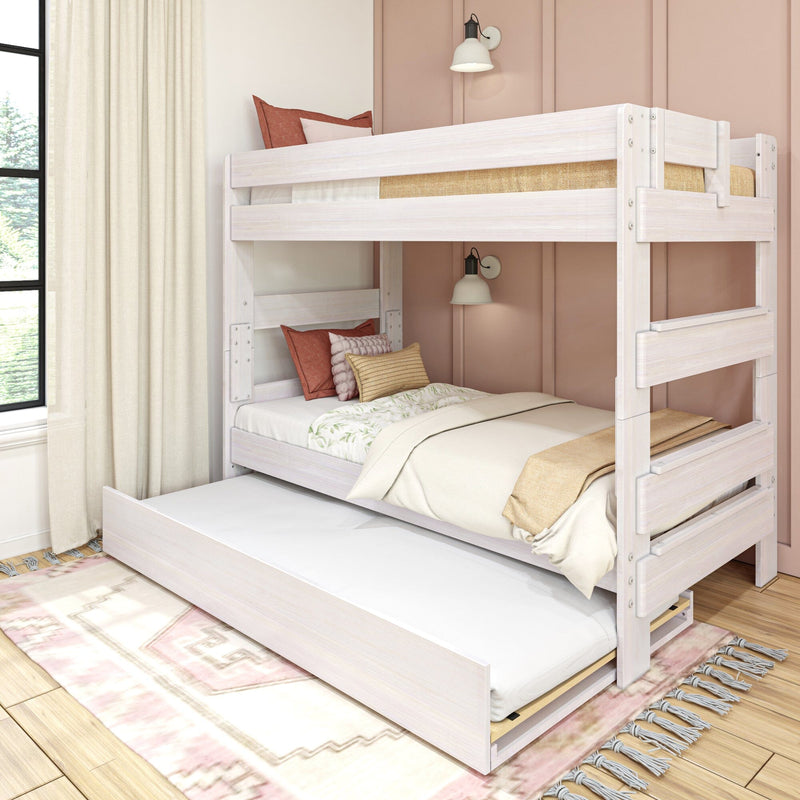 Whitewashed twin bunk bed with pull-out trundle, neutral bedding and terracotta pillows against a blush accent wall with wall sconces in a modern kids' bedroom with hardwood floor and patterned rug
