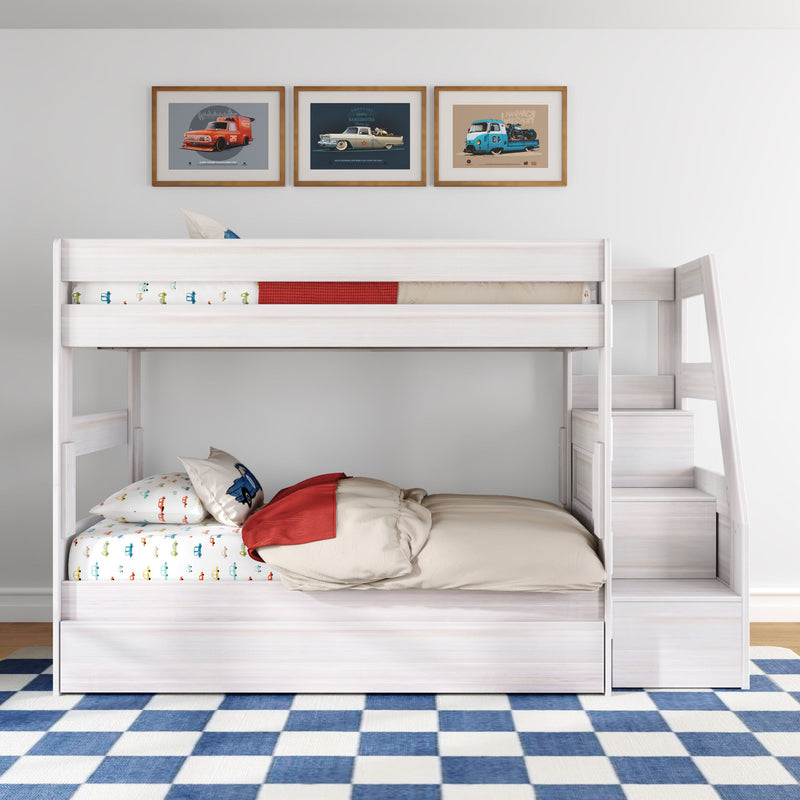 White wooden twin-over-full kids bunk bed with staircase and built-in storage, car-themed bedding and pillows, blue checkered rug and framed vintage car prints in a modern children's bedroom