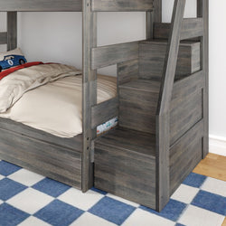 Gray wooden bunk bed with built-in stair storage drawers and lower twin bed in kids' bedroom, blue checkered rug and car-themed pillow