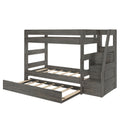 Gray wooden twin-over-full bunk bed with built-in staircase, under-bed trundle, slatted mattress platforms and modern farmhouse finish