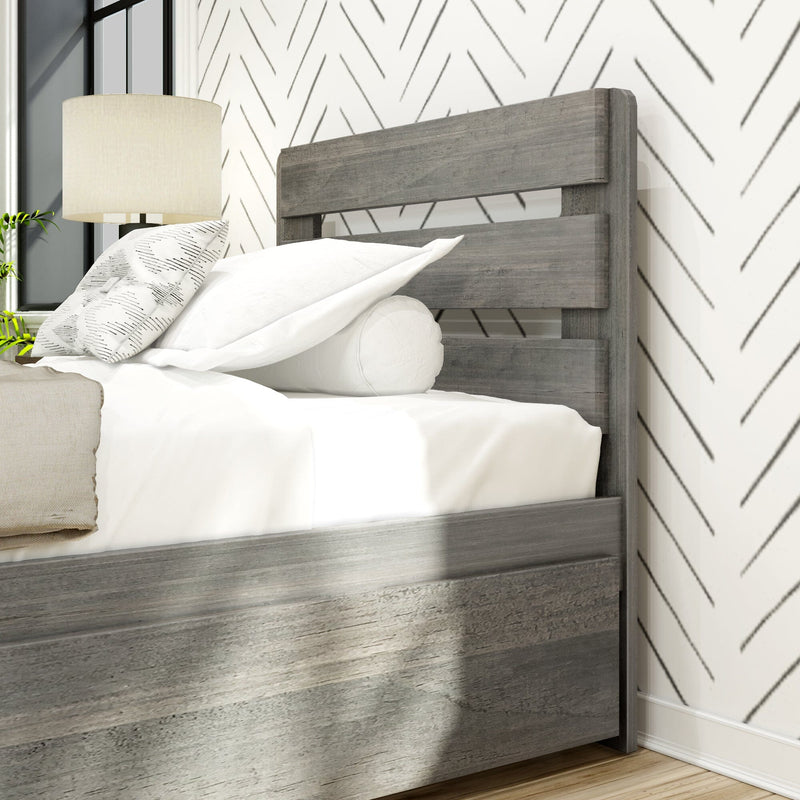 Modern wooden bed frame with chevron pattern wall and cozy white bedding.