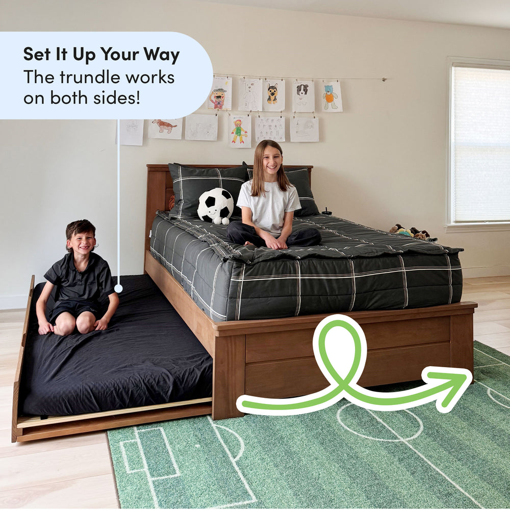 Kids bedroom with versatile trundle bed, soccer-themed decor, and children's artwork display.