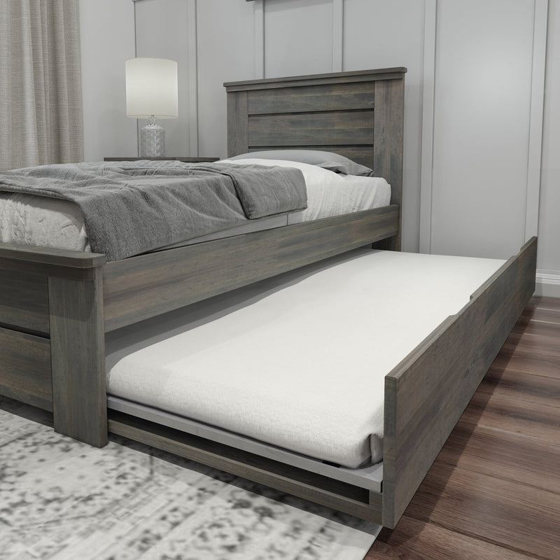 Gray wooden platform bed with pull-out trundle mattress, space-saving storage bed frame in modern rustic bedroom with bedside lamp
