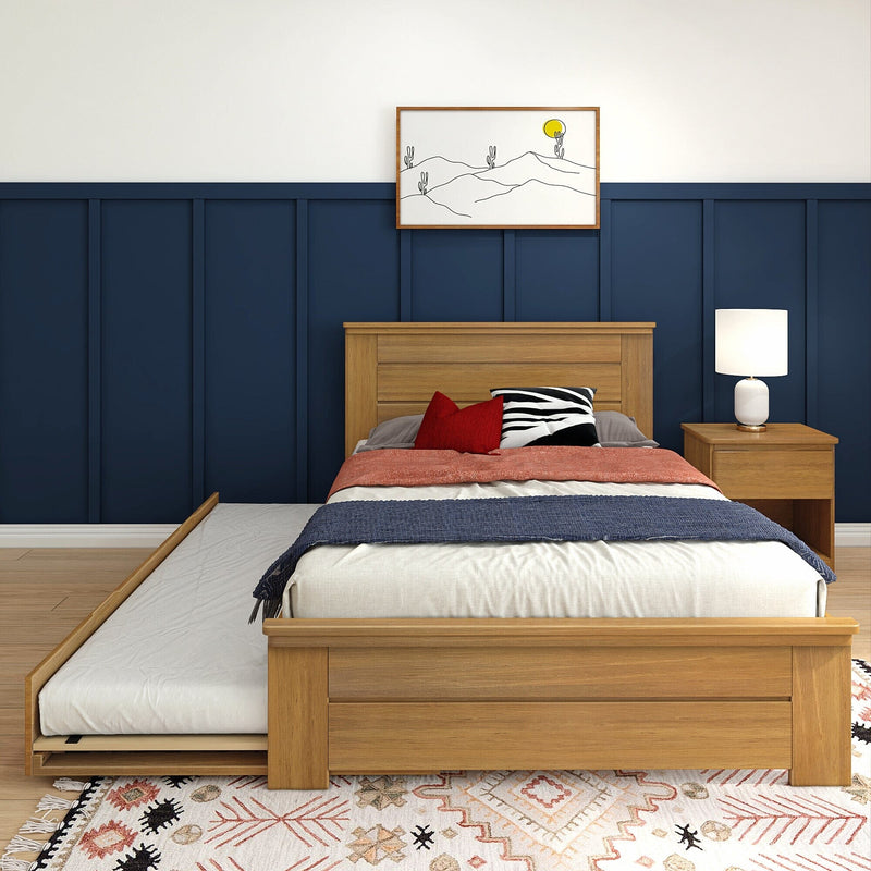 Modern bedroom interior with navy blue paneled accent wall, wooden platform bed, red and zebra pillows, white bedside lamp, minimalist desert wall art and boho patterned rug