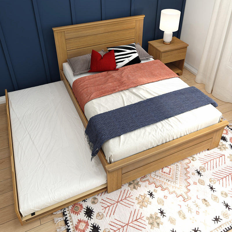 Wooden trundle bed with stylish bedding in a modern bedroom setting.