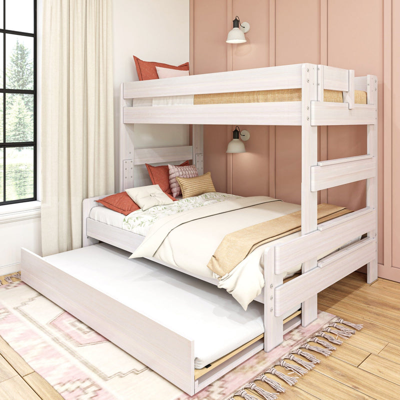 White wooden twin-over-full bunk bed with pull-out trundle in pastel pink kids' bedroom, soft neutral bedding, decorative pillows and natural window light