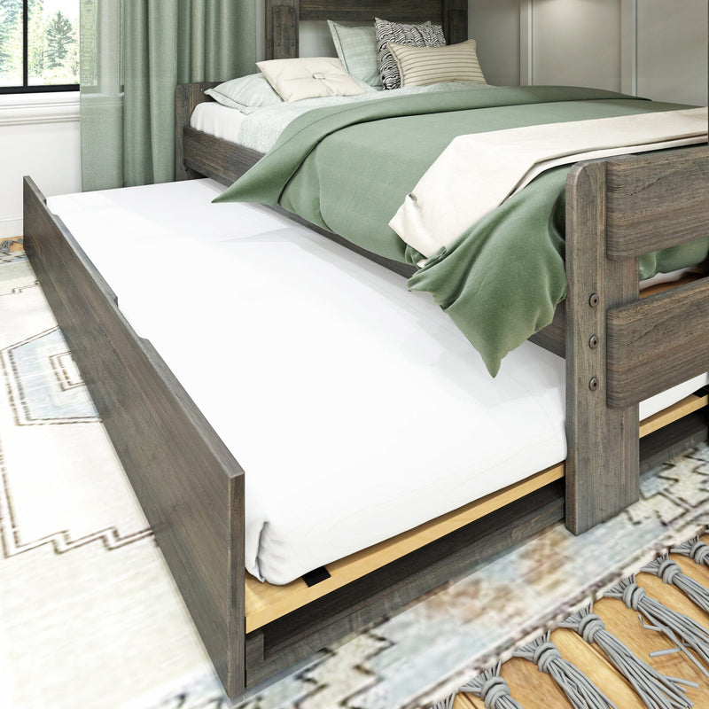 Wooden platform bed with pull-out trundle and green bedding in a cozy bedroom.