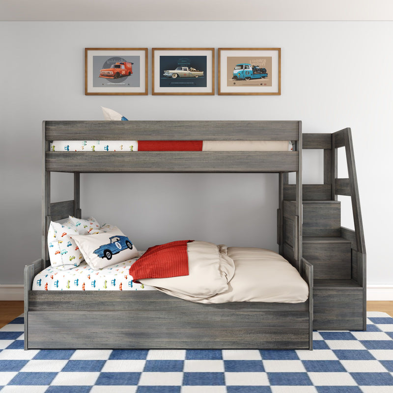 Gray wood kids bunk bed with stairs and storage, car-themed bedding and pillows, framed vintage car prints above and blue checkered rug