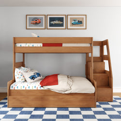 Wooden bunk bed with built-in staircase storage in kids' bedroom, car-themed bedding and framed vintage car prints over blue-and-white checkered rug