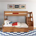 Wooden bunk bed with stairs in kids' bedroom featuring car-themed bedding, framed vintage car wall art and blue checkered rug