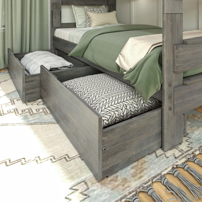 Rustic wooden bed with green bedding and underbed storage drawers on a patterned rug.