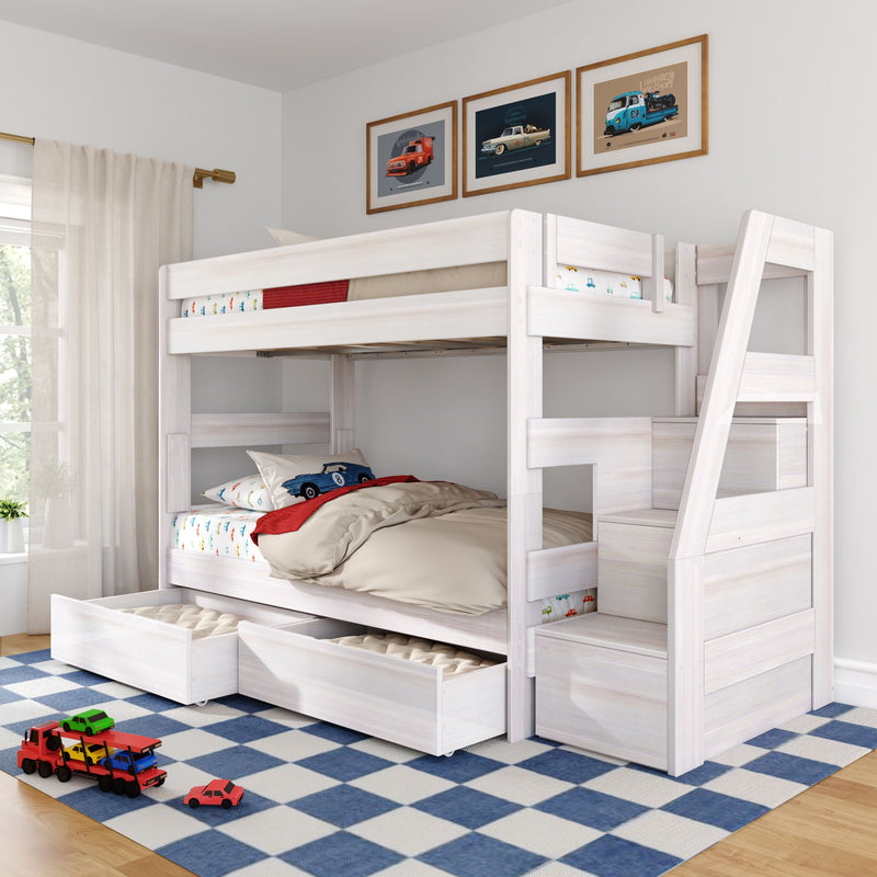 White wooden twin-over-twin bunk bed with staircase and built-in storage drawers in a bright kids' bedroom, car-themed bedding and framed vintage car prints, toy cars on a blue checkered rug