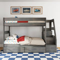 Gray wooden kids bunk bed with built-in stairs and under-bed storage drawers, colorful car-print bedding, red throw and framed vintage car posters on white wall in modern children's bedroom