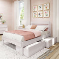 Pastel pink bedroom with white wooden platform bed and underbed storage drawers, blush pink bedding and throw, floral framed gallery wall, sheer white curtains and bedside lamp