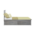 Side view of gray wooden twin bed with light green fitted sheet, textured green throw blanket and matching pillows on white background