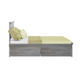 Modern gray wooden platform storage bed with under-bed drawers, matching headboard and light yellow bedding, contemporary bedroom furniture