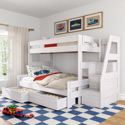 White wooden kids bunk bed with built-in staircase and under-bed storage drawers in a bright, modern children's bedroom with car-themed bedding, toy cars on a blue checkered rug, framed vintage car prints and a sunlit window.