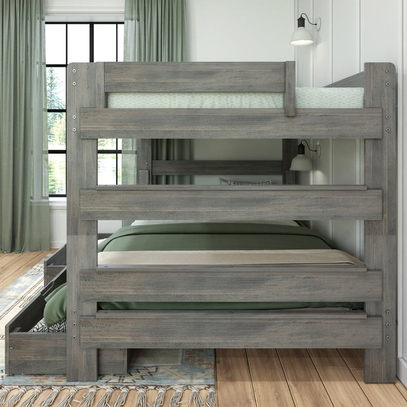 Graywashed twin-over-full wooden bunk bed with pull-out trundle and built-in storage drawer, green bedding, guardrails and wall-mounted reading lamps in a modern farmhouse bedroom with hardwood floors, large window and sage curtains