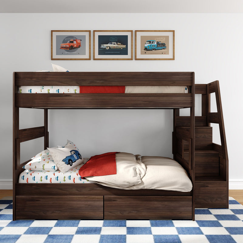 Dark walnut two-level wooden bunk bed with staircase and under-bed storage drawers, styled with car-themed bedding, red throw, blue checkered rug, and framed vintage car wall art in a child's bedroom.
