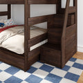 Dark walnut wooden bunk bed with built-in staircase storage, beige bedding, car-print pillow and blue plaid rug in a kids' bedroom