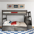 Gray wooden kids bunk bed with car-themed bedding and racing car pillow, red throw blanket, built-in under-bed storage drawers, framed vintage car wall art and blue checkered rug in a modern children's bedroom