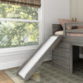 Grey wooden loft bed with slide, pink bedding and stuffed bunny beside a large window in a modern kids' bedroom