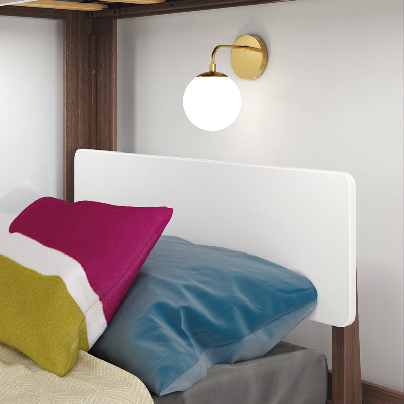 Brass globe wall sconce above bunk bed with wooden frame, white headboard and colorful pillows, modern bedside lighting