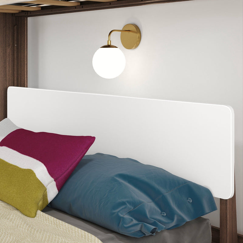 White modern headboard with brass globe wall sconce, colorful pillows and blue duvet on wood bed frame