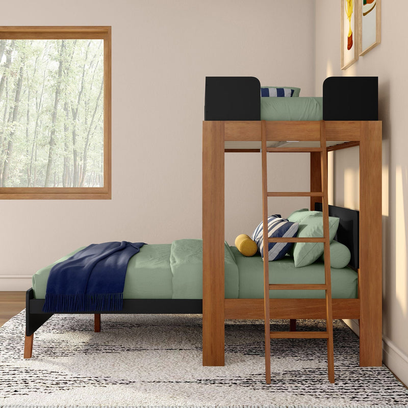 Wooden twin-over-twin bunk bed with ladder, green bedding and navy throw in kids' bedroom with patterned rug and forest-view window