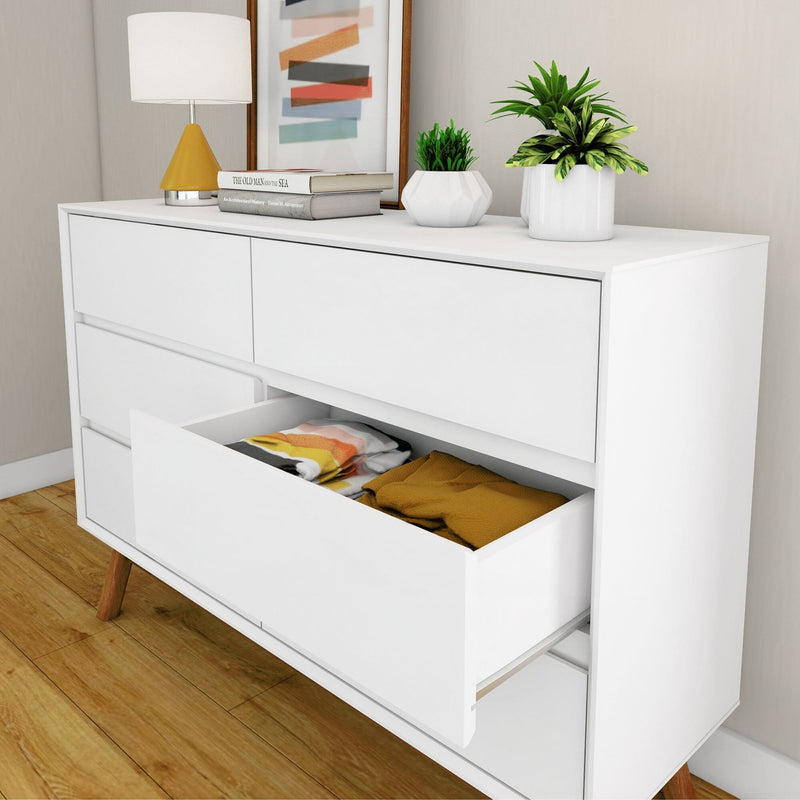 Modern white dresser with open drawers, displaying neatly folded clothes, on a wooden floor, perfect for bedroom storage solutions.