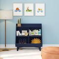 Navy blue children's bookshelf in nursery with kids' books, wooden toys, smiling sun cushion, watercolor animal car wall art, floor lamp and orange pouf