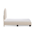 Side view of beige upholstered platform bed with tall fabric headboard and white mattress