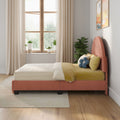 Modern cozy bedroom interior with coral upholstered bed and yellow bedding, decorative pillows, wooden casement window with sheer curtains, potted plants and natural light.