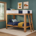 Wooden kids bunk bed with ladder, navy bedding and pillows on green wallpaper, framed trophy and sneaker prints, forest-view window