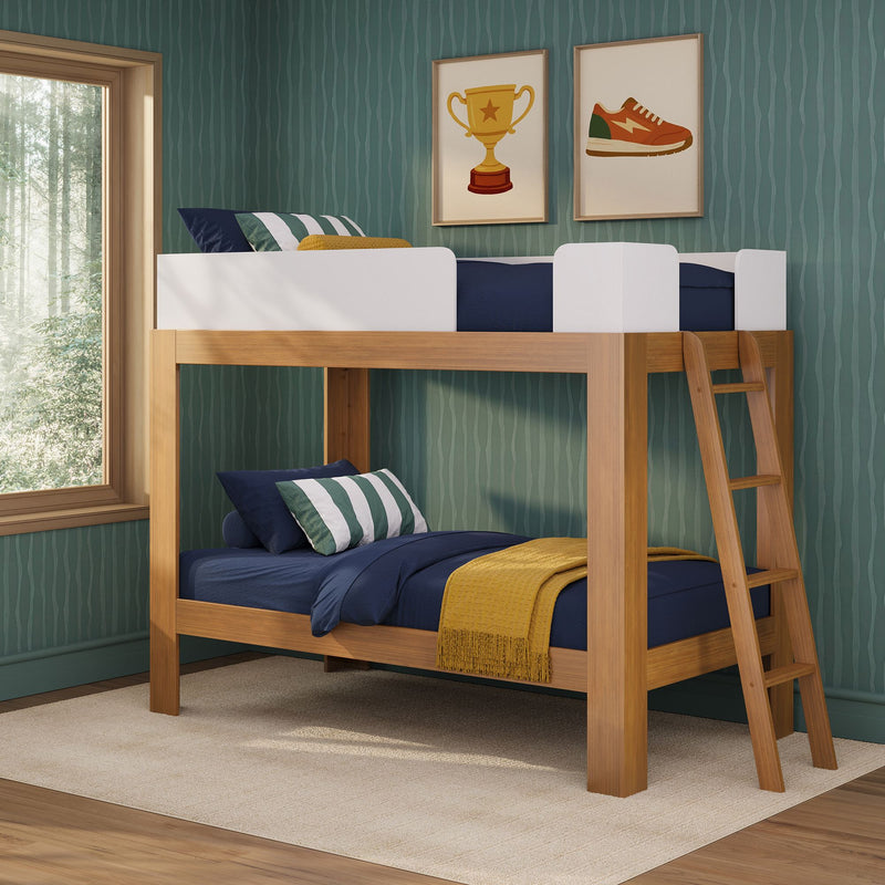 Wooden kids bunk bed with ladder, navy bedding and pillows on green wallpaper, framed trophy and sneaker prints, forest-view window
