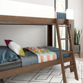 Modern solid wood loft bunk bed with ladder, blue bedding and colorful throw in a bright minimalist bedroom with potted plant