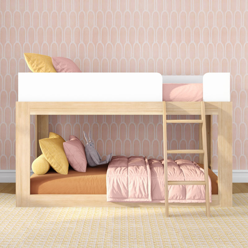 Modern natural wood loft bunk bed with ladder in pastel kids bedroom, pink quilt, yellow pillows, stuffed rabbit and arched pink wallpaper — children's bedroom decor