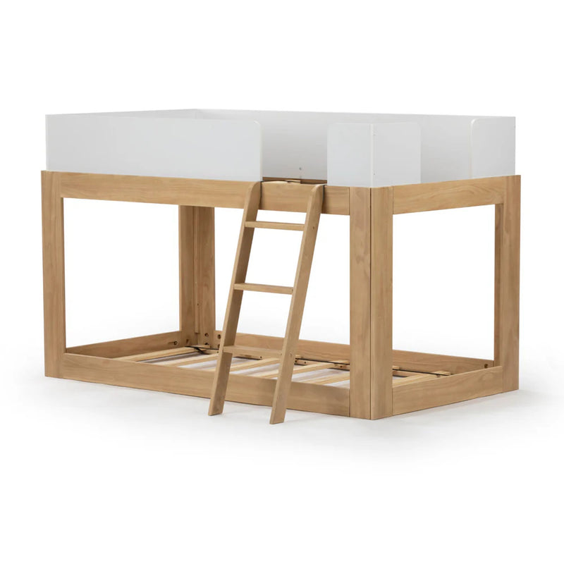 Children's wooden loft bed with ladder and white guardrails.