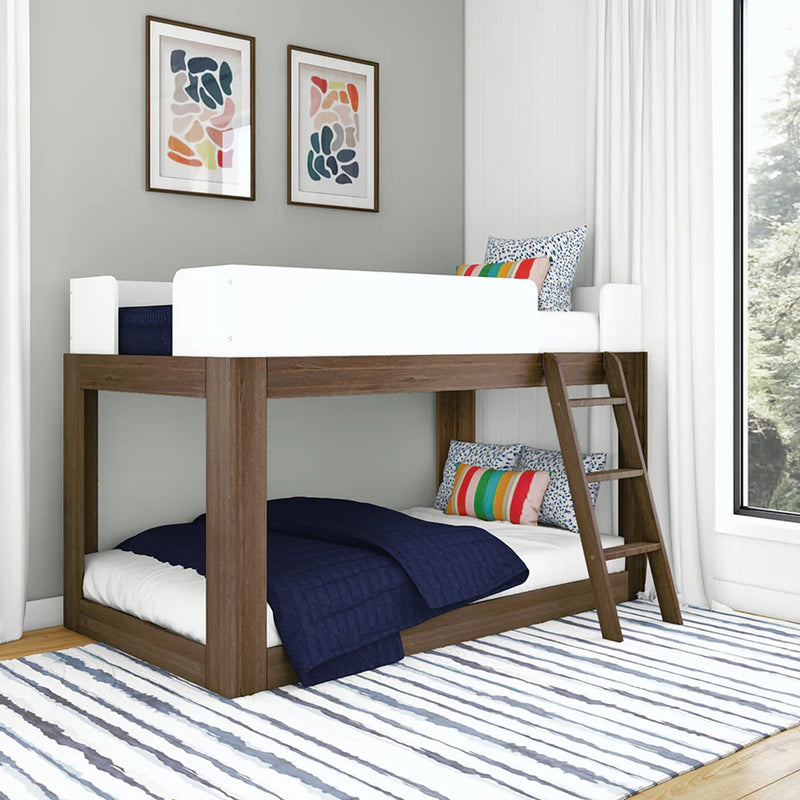 Modern wooden bunk bed for kids with ladder and twin mattresses, navy quilted bedding, colorful striped pillows, framed abstract wall art, white curtains and striped area rug in a bright contemporary bedroom