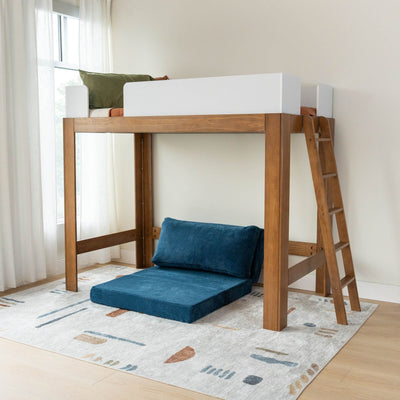 Modern wooden children's loft bed with ladder, blue floor cushion reading nook and patterned area rug